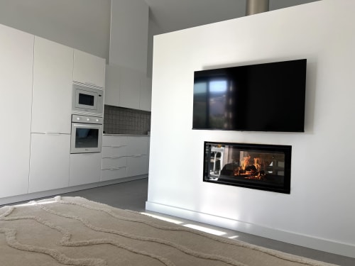 Sala de estar moderna de villa com lareira, TV na parede e cozinha aberta em Bordeira, Portugal