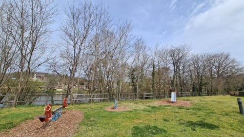 Espaces extérieurs spacieux à Conciergerie Pour Tous avec équipements de jeux, arbres nus et pelouses près de Darazac