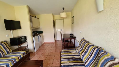 Spacieux appartement à la Conciergerie Pour Tous à Darazac avec canapés rayés, kitchenette et équipements modernes