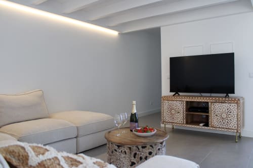 Sala de estar moderna da villa Casa Amoreira com sofá, mesa de centro em madeira e TV de tela plana em painel decorativo