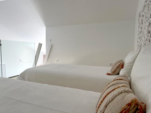 Quarto minimalista luminoso na villa Casa Amoreira em Bordeira com roupa de cama branca, vigas de madeira e vista para o mar
