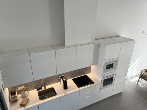 Cozinha branca moderna com ilha, cooktop a gás, pia e forno duplo embutido na villa Casa Amoreira em Bordeira,