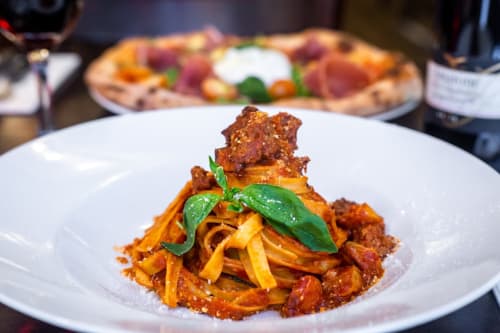 Piatto di pasta gourmet con carne croccante e basilico fresco a Villa Vista Lago di Como, Bellano