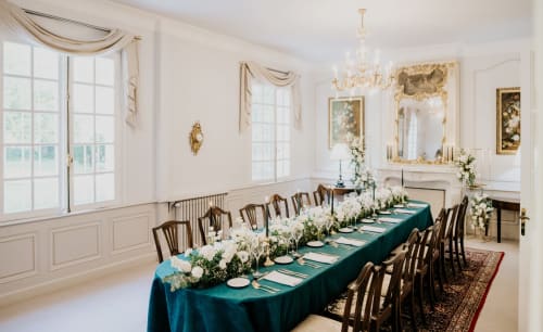 Élégante salle à manger du Domaine de Bize avec table drapée de teal, fleurs blanches et lustre en cristal à Mirepoix