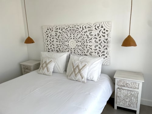 Quarto moderno da villa Casa Arrifana em Bordeira com cabeceira branca entalhada, almofadas decorativas, luminárias pendentes e detalhes esculpidos