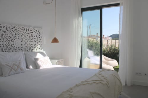 Quarto moderno e luminoso na villa Casa Arrifana em Bordeira com roupa de cama branca, cabeceira estampada, luminária cobre