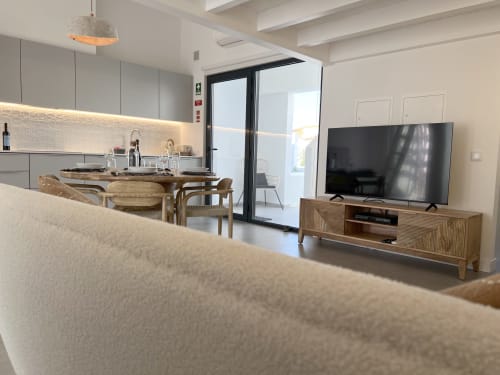 Sala de estar moderna com cozinha, zona de refeições, smart TV e vistas para o mar na Casa Arrifana, Bordeira