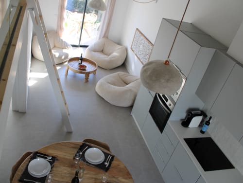 Interior moderno da Casa Arrifana com cozinha integrada, sala de jantar e nichos brancos com vista para o mar