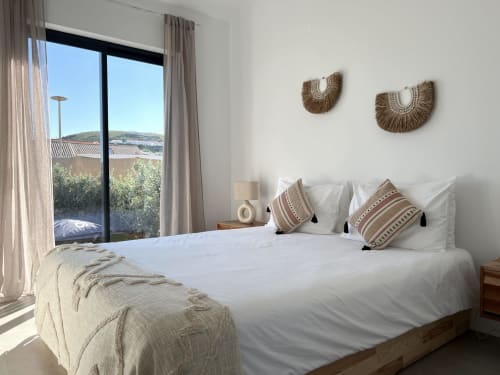 Quarto luminoso na villa Casa Castelejo em Bordeira com vista para o mar, cama branca, arte têxtil decorativa e varanda panorâmica
