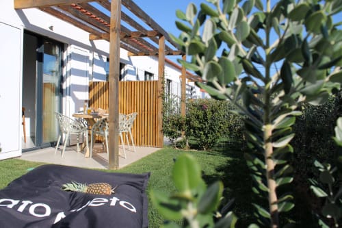 Casa Castelejo villa in Bordeira with wooden pergola, outdoor dining area, furnished terrace, and lush garden with sea views.