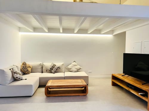Sala de estar moderna na villa Casa Castelejo com sofá secional branco, mesa de café em madeira, TV de tela plana e design minimalista