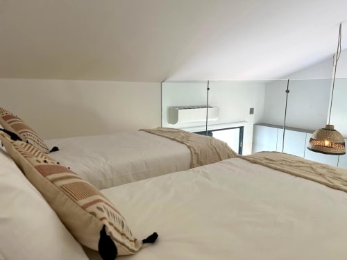 Quarto mezzanino moderno na villa Casa Castelejo em Bordeira com duas camas, luminárias suspensas e vista para o mar