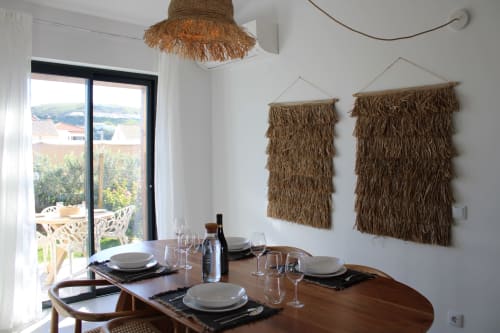 Sala de jantar da villa Casa Cordoama em Bordeira com vista para o mar, mesa de madeira, tapeçarias tecidas e acesso ao terraço
