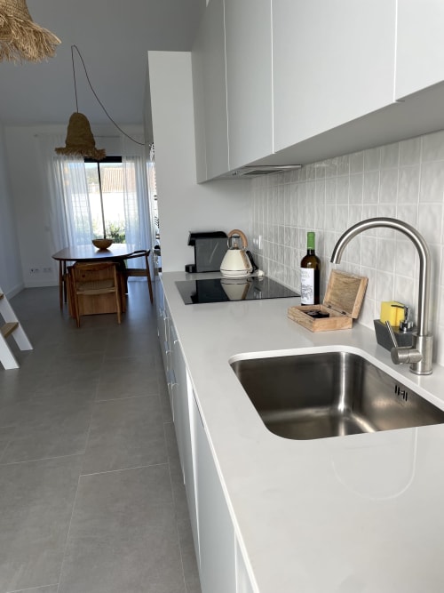 Cozinha moderna com pia em aço inoxidável, bancadas brancas e ilha na villa Casa Cordoama, Bordeira Portugal