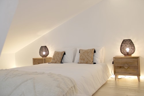Quarto minimalista luminoso na villa Casa Cordoama com roupa de cama branca, mesas de cabeceira em madeira, luminárias de vime e branco angular