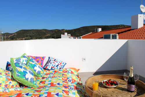 Colorful bedding on terrace at Casa Cordoama villa in Bordeira with champagne, orange juice and strawberries overlooking