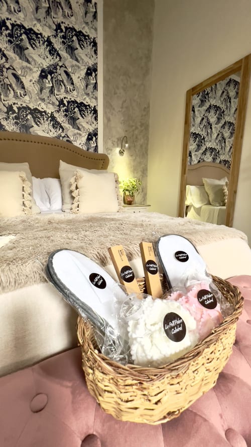 Canasta de bienvenida de lujo con pantuflas y artículos de tocador en el apartamento Wehost Costaluz de Puerto Santa María