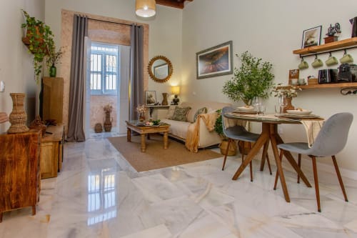 Moderno apartamento en Puerto Santa María con muebles de madera, comedor, sala de estar, pisos de mármol y plantas verdes