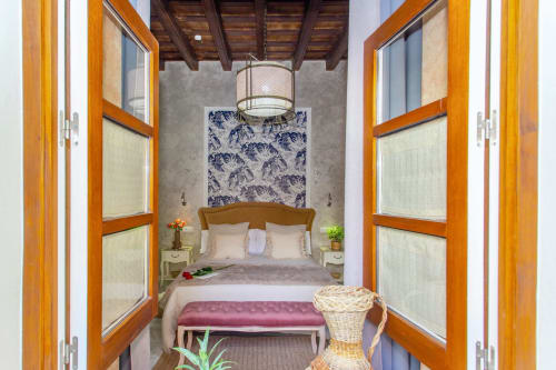 Dormitorio en apartamento de Puerto Santa María con puertas de madera, cabecero de patrón azul y mobiliario elegante