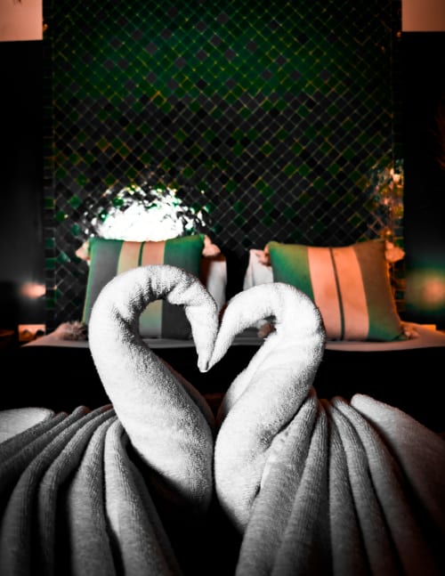 Decorative white towel swans with heart shape in Jade room at Riad Les Lauriers Blancs, Marrakech