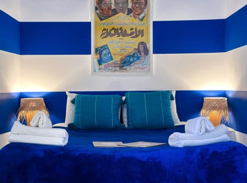 Sapphire room at Riad Les Lauriers Blancs in Marrakech with vibrant blue walls, teal pillows, and folded white towels on bed