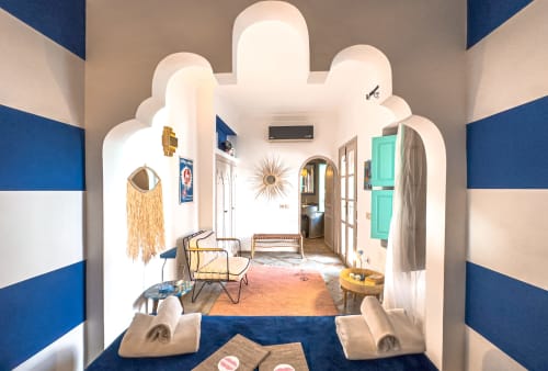 Chambre Saphir au Riad Les Lauriers Blancs à Marrakech avec murs à rayures bleues, plafond voûté et mobilier contemporain