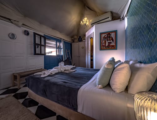 Chambre turquoise au Riad Les Lauriers Blancs à Marrakech avec lit, canapé, porte bleue et décor traditionnel