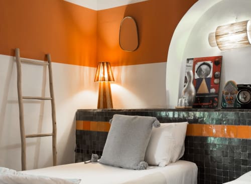 Chambre Pearl du Riad Les Lauriers Blancs à Marrakech avec murs orangés, tête de lit carrelée et décoration moderne
