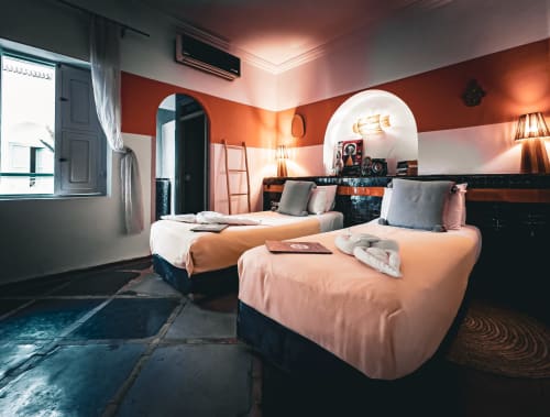 Chambre Pearl du Riad Les Lauriers Blancs à Marrakech avec lits jumeaux, mur orange et éclairage chaleureux