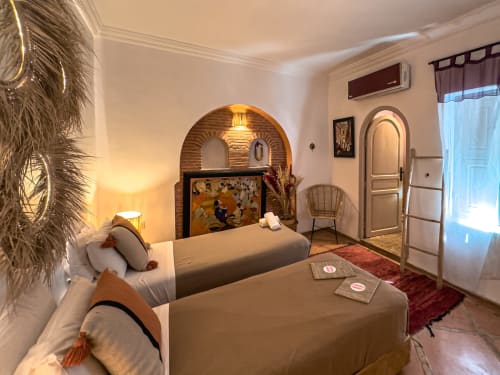 Chambre ambrée du Riad Les Lauriers Blancs à Marrakech avec lits jumeaux, alcôve voûtée et décor marocain traditionnel