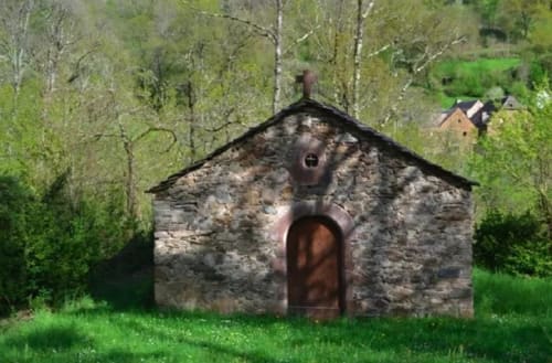 Chapelle en pierre historique entourée de verdure au Domaine du Bez à Saint Laurent d'Olt, France