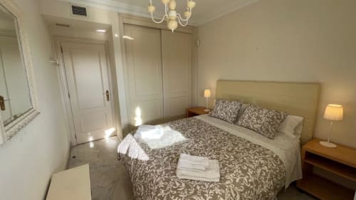 Elegant bedroom at Marbella Home Rentals Marina Banús apartment with queen bed, patterned bedding, twin nightstands,