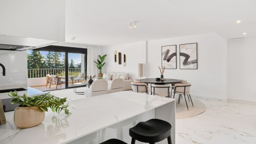 Modern Marbella apartment kitchen and dining area with mountain views, marble countertops, and contemporary furnishings
