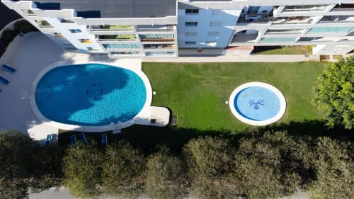 Aerial view of Casaño apartment in Marbella with oval pool, hot tub, and manicured gardens surrounded by modern buildings