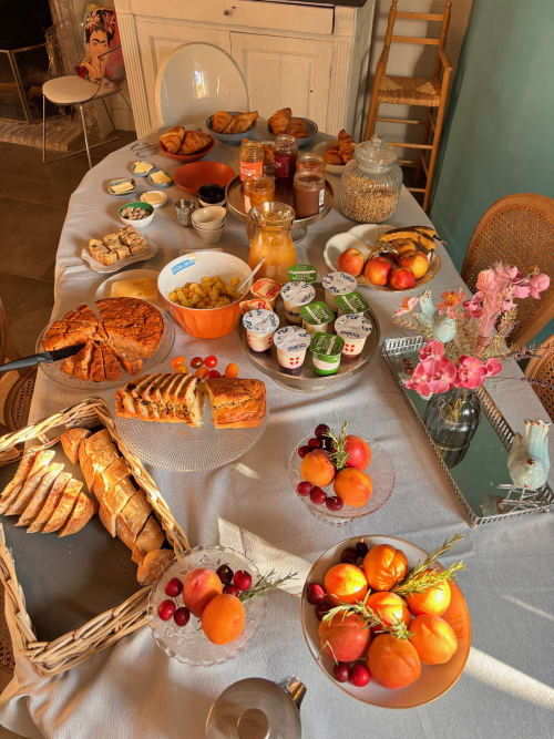 Petit-déjeuner gastronomique à La vie de château B&B à Grignan avec viennoiseries, pains frais, fruits, confitures et fleurs