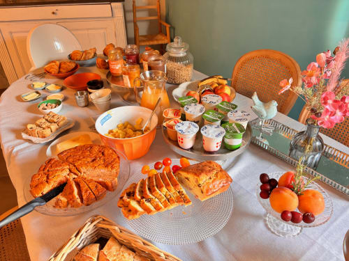 Petit-déjeuner élégant à La vie de château B&B à Grignan avec viennoiseries, fruits frais, yaourt et jus d'orange.