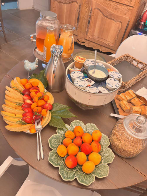 Petit-déjeuner copieux à La vie de château B&B à Grignan avec fruits frais, viennoiseries, confitures et jus d'orange