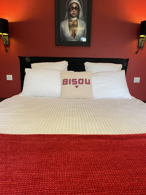 Chambre luxueuse au spa Lady Jule avec murs rouges, literie blanche et art contemporain au-dessus du lit
