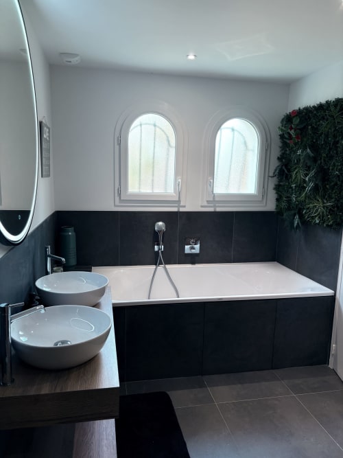 Salle de bain moderne à Lady Jule B&B avec carrelage noir, vasques rondes et fenêtres cintrées donnant sur le jardin