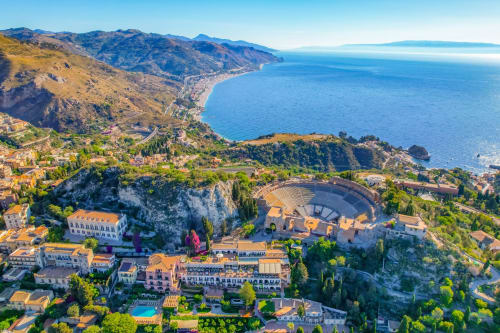 Luftaufnahme des Hotel Milomax in Taormina mit antkem Amphitheater, Küstenstadt und Mittelmeer