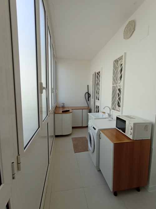 Moderna lavanderia nell'appartamento Casa Vacanze Alba con lavatrice, microonde e lavello nella struttura vacanziale di Bari