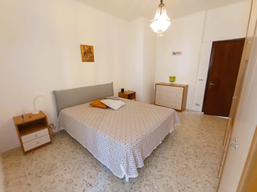 Spaziosa camera da letto in Casa Vacanze Alba, appartamento a Bari con letto matrimoniale, mobili in legno e pavimentazione in cotto