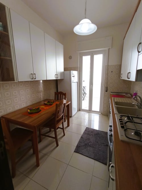 Moderna cucina in Casa Vacanze Alba, appartamento a Bari con tavolo da pranzo, elettrodomestici e accesso alla vista mare