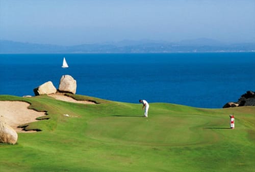 Golfeur en train de putter sur le parcours du Golf de SPERONE  surplombant la mer bleu à trois kms de  Villa Marina di Cavu, Bonifacio 