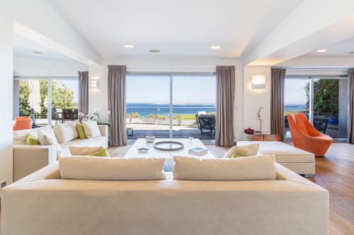 Suite Marina Di Cavu moderne à Bonifacio avec vue panoramique sur la mer, canapés crème et touches d'orange