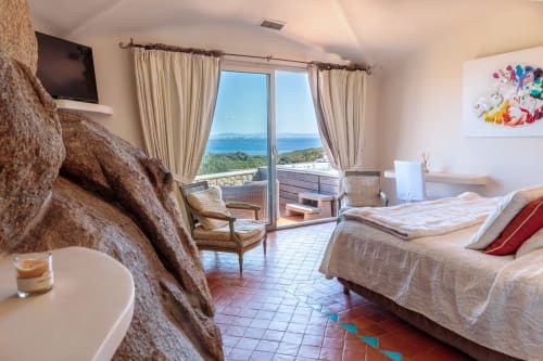 Chambre spacieuse à Villa Marina Di Cavu avec balcon vue mer, lits et TV dominant la côte de Bonifacio