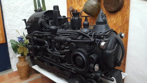 Maquette de locomotive créée à partir de matériaux recyclés : pots de confiture, couvercle d’autocuiseur, dévidoir de rouleaux WC et autres éléments détournés. Une œuvre de recyclage artistique signée Florent Arnaud, visible au Portel des Arnaud, chambres d'hôtes dans les Cévennes, sud de la France. Séjour nature et détente