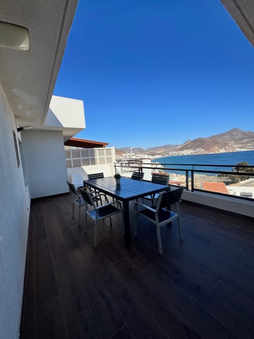 Terraza moderna con vistas al mar Mediterráneo en San José, Almería con mesa de comedor y vistas a las montañas