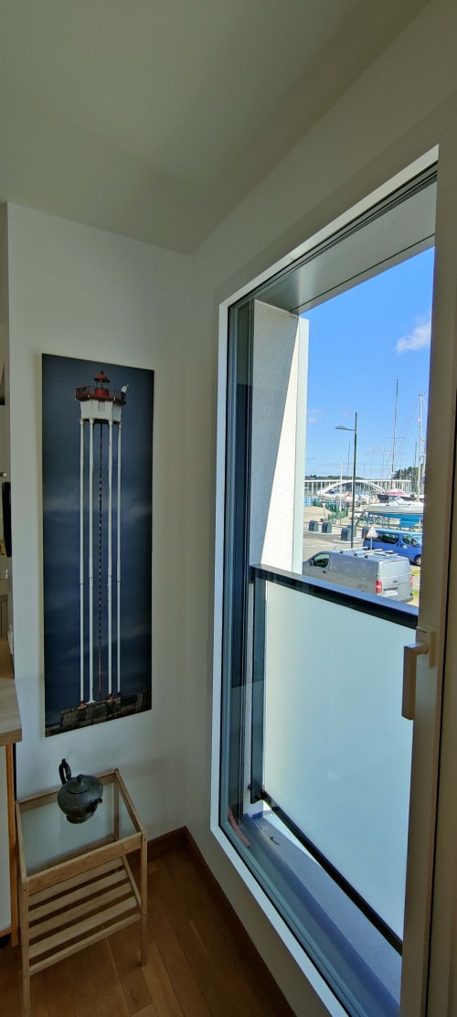 Vue sur la marina depuis la chambre de l'hôtel Mer et Maisons à La Trinité sur Mer avec décoration phare