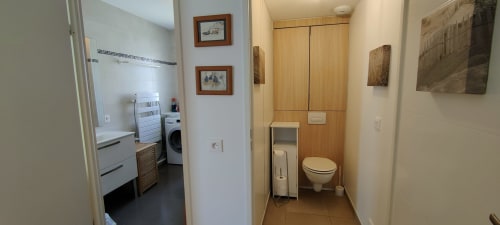 Salle de bain et buanderie de l'hôtel Mer et Maisons à La Trinité sur Mer avec toilettes, lavabo et machine à laver